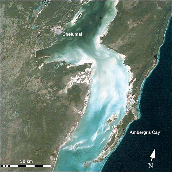 Chetumal Bay lies on the border between Mexico and Belize. To the east of the bay, Ambergris Cay (in Belize) connects the Belize Barrier Reef to the Yucatan Peninsula (Mexico). The north of the island is Bacalar Chico Marine Reserve. Here, the barrier reef comes very close to the east side of the island. Image courtesy of NASA.