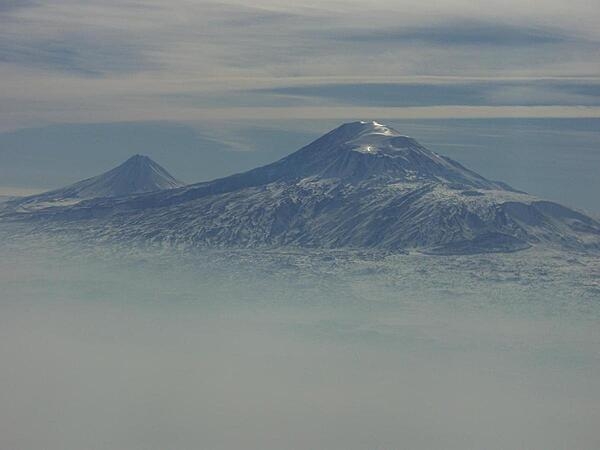 A view of Mount Ararat in western Turkey through the fog. The highest of its two peaks, Greater Ararat, is the tallest mountain in Turkey at 5,166 m (16,949 ft). Although located some 32 km (20 mi) from the Armenian border, the dormant volcano dominates the skyline of Yerevan, Armenia's capital. This photo was snapped after take-off from the Yerevan airport.