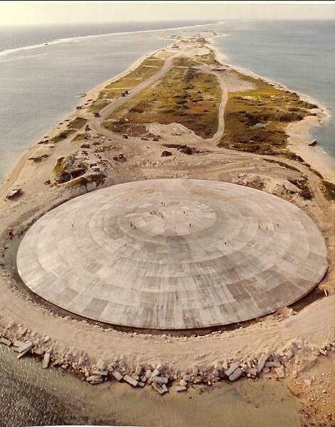 Aerial view of Runit Dome (or Cactus Dome) on Runit Island in Enewetak Atoll in the Marshall Islands. Between 1977 and 1980, the crater created by the Cactus shot from Operation Hardtack I was used as a burial pit for radioactive soil scraped from contaminated Enewetak Atoll islands. The Runit Dome was built to cover the material. Photo courtesy of US Department of Defense.