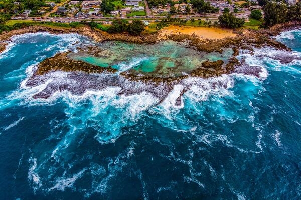 Aerial view of Shark's Cove at Pupukea Beach Park on Oahu's North Shore in Hawaii. The Cove is a large set of tidal pools protected by a natural breakwater.