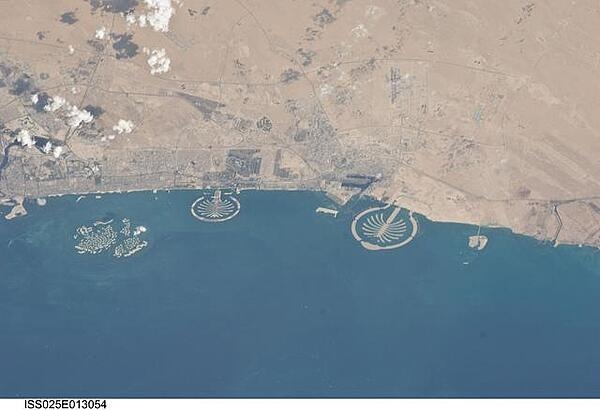 Three man-made archipelagos near Dubai, United Arab Emirates, are featured in this image from the International Space Station (ISS), flying at 350 km (220 mi) above Earth. The municipality of Dubai is the largest city of the Persian Gulf emirate of the same name, and has built a global reputation for large-scale developments and architectural works. Among the most visible of these developments - particularly from the perspective of astronauts onboard the ISS - are three man-made archipelagos. The two Palm Islands - Palm Jumeirah to the left of center, and Palm Jebel Ali, just to the right of center, appear as stylized palm trees when viewed from above. The World Islands (near left edge) evoke a rough map of the world from an air- or space-borne perspective. Image courtesy of NASA.
