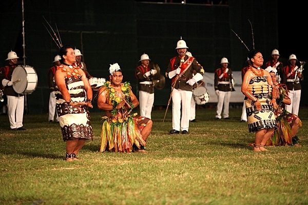 Tongan performers dance the tau’olunga while the Royal Corps of Musicians play music during the Kingdom of Tonga military parade and tattoo on 2 August 2011. A tattoo is comprised of military units – musical and operational – from different countries collaborating in an extensive exhibition of musical performances and demonstrating military capabilities. Photo courtesy of the US Marine Corps/ Staff Sgt. Christine Polvorosa.