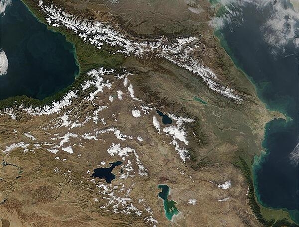 Often regarded as the southeastern border of Europe, the Caucasus Mts stretch from the Black Sea (left) to the Caspian Sea (right). The mountain range spans 1,125 km (700 mi), forming part of the southern Russian border, and crossing Georgia, Armenia, and Azerbaijan from left to right respectively. With a snowline of approximately 3,350 m (11,000 ft) and many peaks over 4,500 m (14,760 ft), much of the snow seen in this image is present year round. Also visible in this photo are apparent phytoplankton blooms in the Caspian Sea, marked by blue-green swirls. Image credit: NASA.