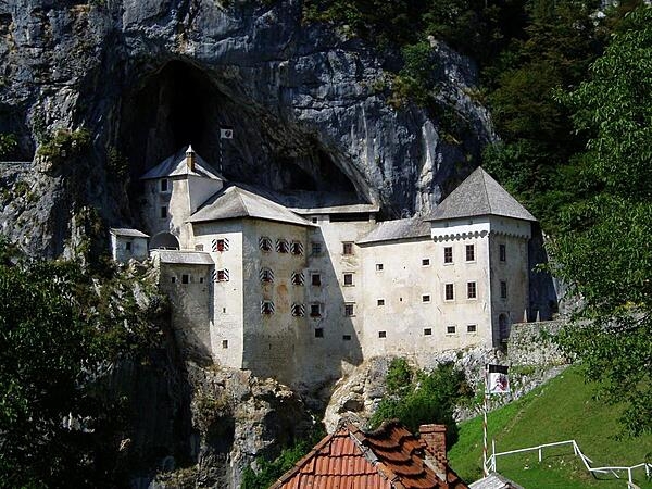 Predjama Castle, built in the mouth of a cave complex set halfway up a 123 m (400 ft) vertical cliff face at the end of a valley in southwest Slovenia, is known as one of the most-extraordinary castles in the world. The first castle, constructed in 1274 in the Gothic style, was destroyed in a siege and later rebuilt, only to be destroyed again in an earthquake in 1511.  In 1570, the current castle was rebuilt in the Renaissance style, pressed next to a vertical cliff under the original medieval fortification. The castle has remained in this form, virtually unchanged, to the present day.
