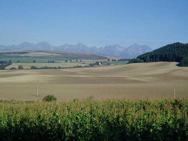 The Slovakian countryside, with the Tatra Mountains visible in the distance. The Tatras are the highest range in the Carpathian Mountains and form a natural border between Slovakia and Poland. About 78% of the Tatras lie within Slovakia, as does the highest peak, Gerlachovsky Stit, at 2,655 m (8,710 ft).
