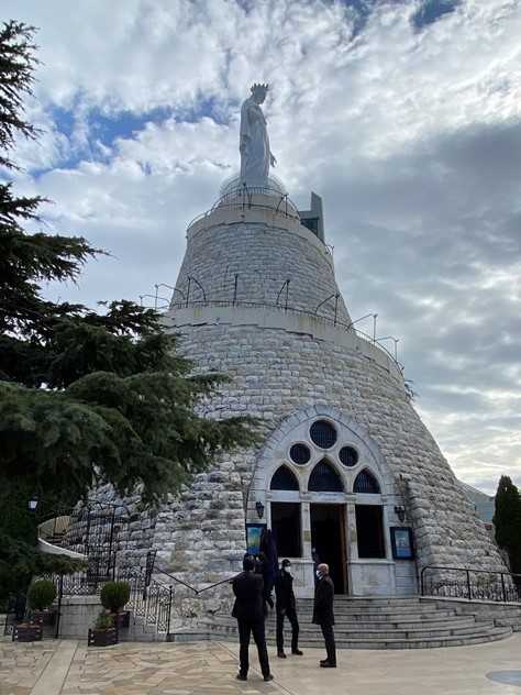 The Shrine of Our Lady of Lebanon is a Marian shrine and a Christian pilgrimage site in Harissa, Lebanon. Erected in 1907 and dedicated in 1908, the bronze statue weighs 11.7 metric tons (13 tons) and stands 8.5 m (27 ft) tall, stretching her hands toward nearby Beirut. The statue’s stone pedestal is nearly 20 m high (66 ft) and houses the Our Lady of the Light Chapel.