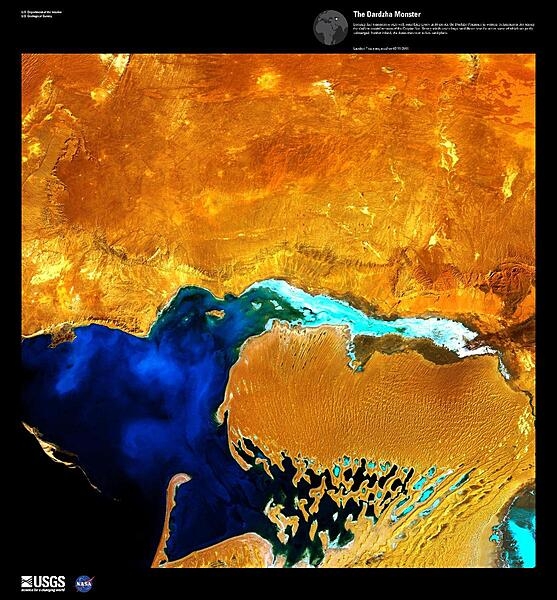 Looking like a monstrous ogre with something gooey in its mouth, this enhanced satellite image shows the Dardzha Peninsula in western Turkmenistan, which lies among the shallow coastal terraces of the Caspian Sea. Strong winds create huge sand dunes near the water, some of which are partly submerged. Further inland, the dunes transition to low sand plains. Image courtesy of USGS.