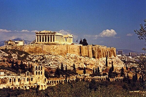 The Parthenon crowns the Acropolis in Athens. The Acropolis is a citadel on a flat, high, rocky outcrop 150 m (490 ft) above sea level and is the highest point in Athens. It preserves a number of ancient structures.