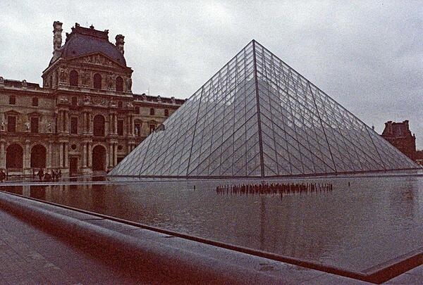 The Louvre in Paris, France, is the largest museum in the world. This view features the Paris Pyramid at the main entrance, designed by I.M. Pei and completed in 1988. Constructed of glass and metal, the structure stands 21.6 m (71 ft) tall and replicates the Great Pyramids of Giza.