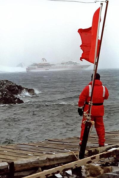 On shore, passengers and crew wear bright colors to avoid getting lost on the ice. The flag marks the landing spot for the Zodiacs (inflatable boats used for transport from the cruise ship).
