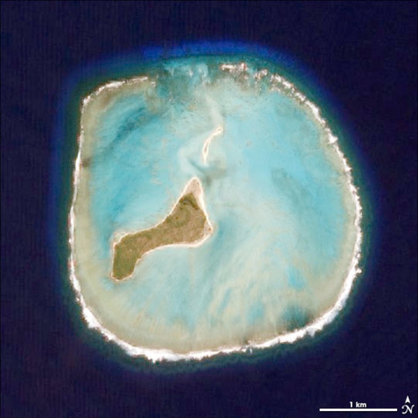 Oeno Island, the westernmost of the Pitcairn Islands, has a distinctive, circular fringing reef clearly seen in this view from space. While the island is uninhabited, it is also referred to as Holiday Island because it serves as a private vacation destination for the residents of Pitcairn Island, who travel there and stay for a few weeks in January because Oeno has beaches while Pitcairn has none. Fresh water is pumped out of a well dug in the sand. Photo courtesy of NASA.