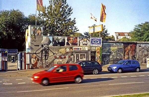 A preserved portion of the Berlin Wall in Germany. The wall was begun in 1961 and completely encircled West Berlin until 1989. The former wall is marked in some places by cobblestones.