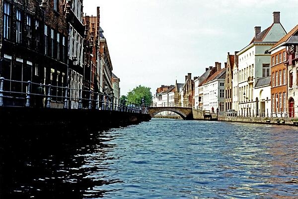 A bridge over a quiet canal in Bruges (or Brugge), Belgium. The name of the city, which is often called the Venice of the North, is believed to come from the Old Norse word "bryggia," meaning "mooring place." The canals were important in getting trading goods to their destination. Today, they are used exclusively for tourist boats.