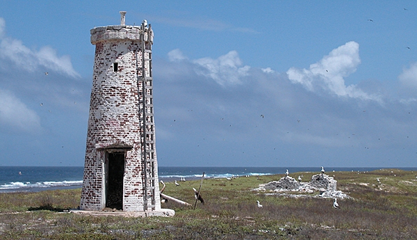 American settlers arrived on Baker Island in 1935 and built a lighthouse; the settlement was evacuated at the start of World War II and the island has been uninhabited and very rarely visited since then. The lighthouse tower still stands; it is now charted as a day beacon (an unlighted nautical sea mark). Image courtesy of the US Fish and and Wildlife Service.