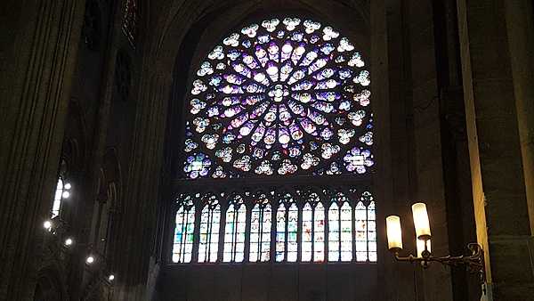 The South Rose Window in Notre Dame Cathedral in Paris, France, was a gift from French King Louis IX in 1260. The stained glass window measures 12.9 m (42 ft) in diameter and contains 84 panes of glass. The themes are the New Testament and the Triumph of Christ reigning over heaven and surrounded by all his witnesses on earth.