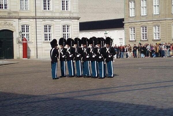 Changing of the guard in the large octagonal courtyard of the Amalienborg Palace in Copenhagen. The plaza is bordered by four buildings with identical facades, which serve as the winter home of the royal family.
