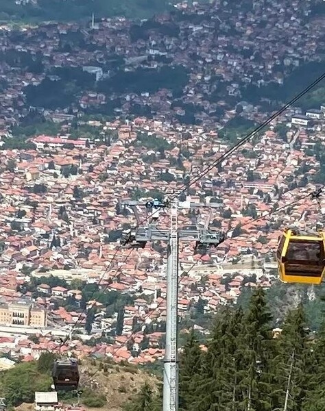 A view of Sarajevo from one of the cable cars that connects the old section of the city with Trebevic Mountain. The original cable car system was built and opened in 1959 but was completely destroyed during the Bosnian War (1992-95). In 2018, the Trebevic Cable Car was officially re-opened as a modernized, faster, and larger system. Today there are 33 cable cars painted in a variety of colors. The new system can transport up to 1,200 passengers per hour in its nine-minute, one-way ride. The new cable car still follows the same route as the previous one, crossing the border that separates the two entities that make up Bosnia and Herzegovina – the Federation of Bosnia and Herzegovina and the Republika Srpska.
