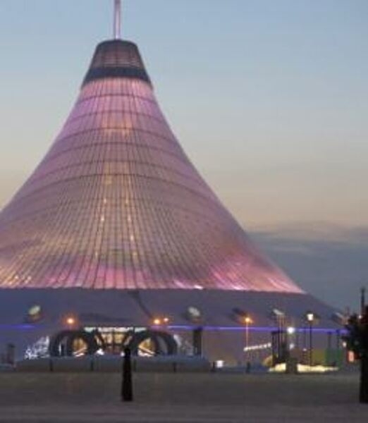 Khan Shatyr (Royal Marquee) is a transparent tent located in the capital city of Astana. Designed in a neofuturist style, the architectural project was constructed between 2006 and 2010. The 90 m (300 ft) high tent covers 140,000 sq m (14 ha; 35 acres). Beneath the canopy, which covers an area larger than 10 football stadiums, is an urban-scale park, a shopping and entertainment venue with squares and cobbled streets, a boating river, a shopping center, a mini-golf center, and an indoor beach resort. The transparent material allows sunlight into the area, moderating its temperature year round.