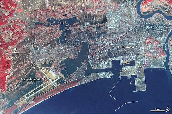 The city of Ishinomaki was one of the hardest hit when a powerful tsunami swept ashore on 11 March 2011. This satellite image is from three days later, when water still inundated the city. Water is dark blue in this false-color image. Plant-covered land is red, exposed earth is tan, and the city is silver. The most extensive flooding may be seen around Matsushima Air Base (lower left corner) where several airplanes were damaged and where the surrounding neighborhoods are flooded. Dark blue fills in the spaces between buildings in sections of Ishinomaki near the harbor (image center) and by the river (upper right). Photo courtesy of NASA.