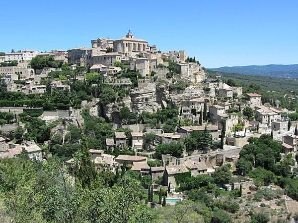 View of Gordes in Provence. The buildings are constructed of white stones and rise in tiers above the Imergue Valley on the edge of the Vaucluse Plateau.