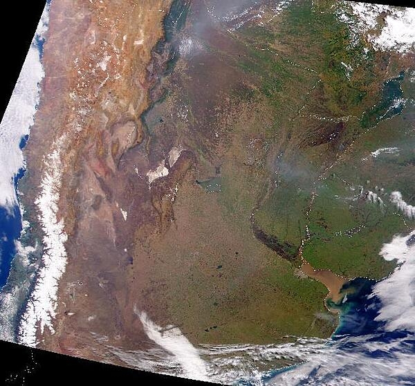 This true-color satellite image of lower South America shows the Andes along the left-hand side, starting out wide up top and narrowing as they move south. The white spine-like strip along the lower Andes is snow. Mount Aconcagua, the tallest mountain in the Western Hemisphere, is located in this section of the Andes. To the east, the muddy green featureless areas in the image are the vast wetlands of Paraguay (further north) and Argentina (in the south). The largest lake in this region is Lake Mar Chiquita, which sits on the western edge of these wetlands. The two whitish tan patches between the lake and the Andes are the much smaller, snow-covered Sierra de Cordoba mountains. Photo courtesy of NASA.