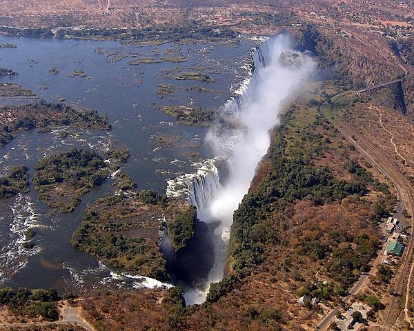 Aerial view of Victoria Falls on the Zambezi River. While the falls are neither the highest nor the widest in the world, during the flood season (February to April) they are the largest, forming the greatest sheet of falling water on earth.