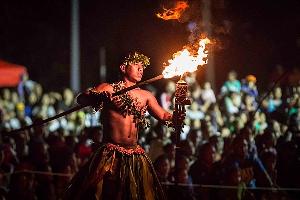 A Tongan fire dancer lights a torch during the Coronation Military Tattoo in Nuku'alofa, on 7 July 2015. A tattoo is comprised of military units both musical and operational, from different countries, performing musically as well as demonstrating military capabilities. Photo courtesy of the US Marine Corps/ Cpl. Brittney Vito.