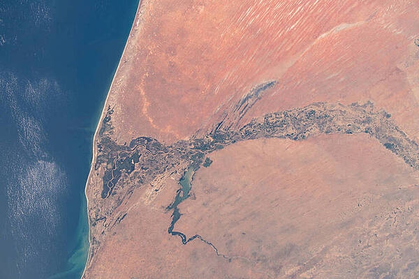 The east-west trending Senegal River that flows into the Atlantic (left) separates the African nations of Senegal (bottom) and Mauritania (top) in this image taken from the International Space Station. The water body south of the river is Lake Guiers. Image courtesy of NASA.