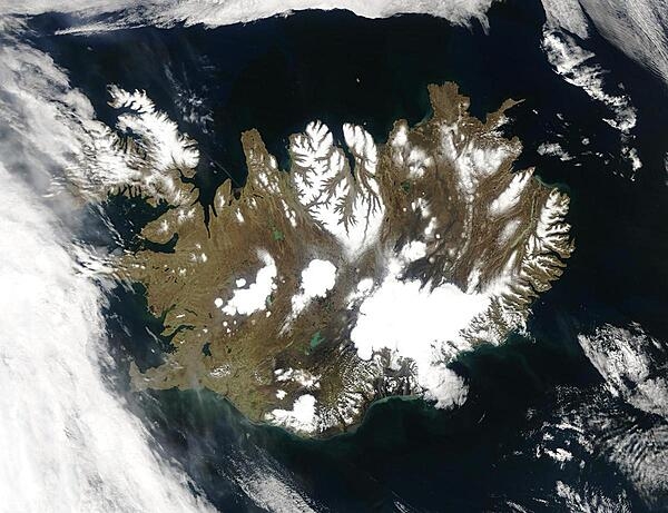 Summer temperatures melt snow and ice on much of Iceland&apos;s surface, as shown on this satellite image. The lack of uniform snow cover allows permanent (though shrinking) icefields to show through (particularly Vatnajokull in the southeast), and highlights the island&apos;s rugged coastline. Scores of fjords edge the island, resembling feathers waving out into the waters of the northern Atlantic Ocean (bottom) and Greenland Sea (upper left). Photo courtesy of NASA.