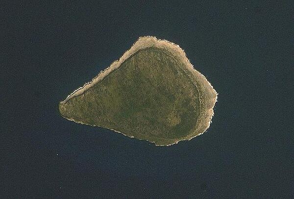 Astronaut photo of teardrop-shaped Navassa Island. The island is basically a plateau encircled by fairly steep cliffs. Image courtesy of NASA.