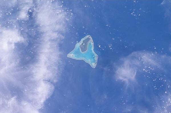 Aitutaki in the Southern Cook Islands has a distinctive equilateral triangular shape (roughly 12 km (7.5 mi) on each side). It is an &quot;almost atoll&quot; whose coral reef barrier does not extend above the ocean along its southern side. Image courtesy of NASA.