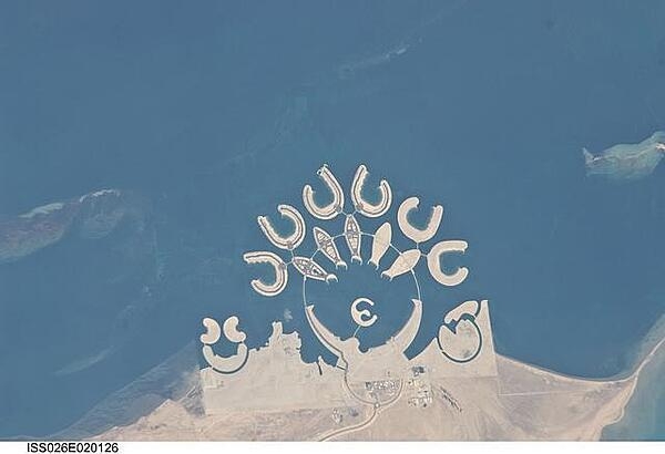 The Durrat Al Bahrain complex is featured in this image photographed from the International Space Station. Set at the southern end of Bahrain Island, at the furthest point from the cities of the kingdom, is this complex of 15 artificial islands designed for residential living and tourism with luxury hotels and shopping malls. Aimed at a cosmopolitan clientele, the Durrat Al Bahrain includes 21 sq km (8 sq mi) of new land for more than 1,000 residences that has been designed as The Islands (six crescent-shaped &quot;atolls&quot; leading off five fish-shaped &quot;petals&quot;). The Crescent at the bottom of the ring is the heart of the complex and features shops, restaurants, hotels, apartments, offices, and schools. The Central  Island is dedicated to one, ultra-luxurious hotel. The three, thick, crescent-shaped islands at the lower left make up the Durrat Marina; the area between the Marina and the Crescent is a golf course. Image courtesy of NASA.