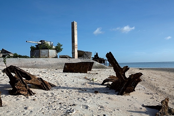 The remains of a Japanese 8-inch coastal defense gun mount sit on the point at Green Beach, Betio Island. Rising above the sand with its muzzle pointed inland, this was one of four 8-inch guns the Japanese emplaced on the island. Shrubs have overtaken the concrete and steel, and hundreds of red crabs race throughout the battlefield debris. Other than some graffiti and weathering, the area remains as it was following the Battle of Tarawa. Photo courtesy of the US Marine Corps/ Cpl. Aaron Hostutler.