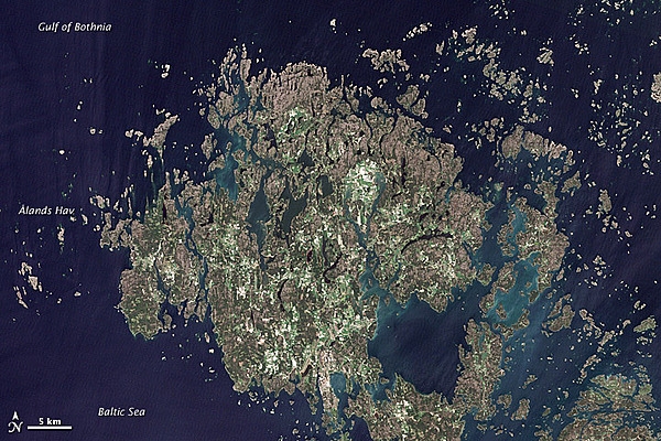 The Åland Islands (pronounced O-lahnd) lie at the southern end of the Gulf of Bothnia, between Sweden and Finland. The archipelago consists of several large islands and roughly 6,500 small isles, many of them too small for human habitation.
Åland vegetation is a combination of pine and deciduous forest, meadows, and farmed fields. 
Image courtesy of NASA/Jesse Allen & Robert Simmon, using USGS Landsat data.