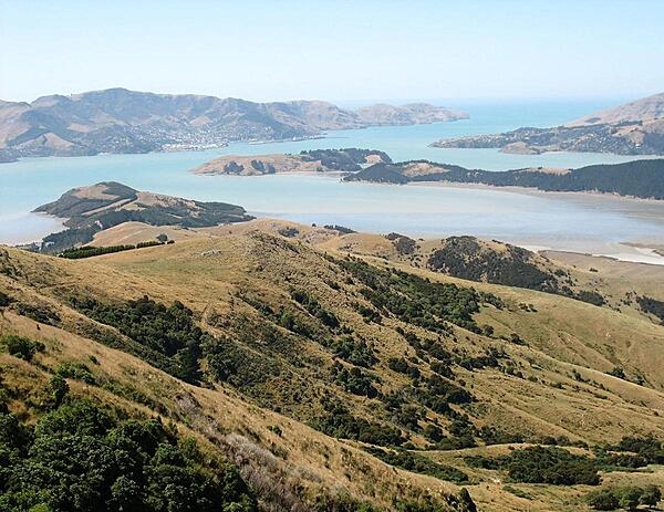 This photo was taken looking southeast on the Banks Peninsula on South Island. The peninsula was formed from eroded remnants of two large composite shield volcanoes, the dominate craters forming the Lyttelton and Akoroa Harbors. The mountainous nature of the peninsula is atypical within the surrounding region.