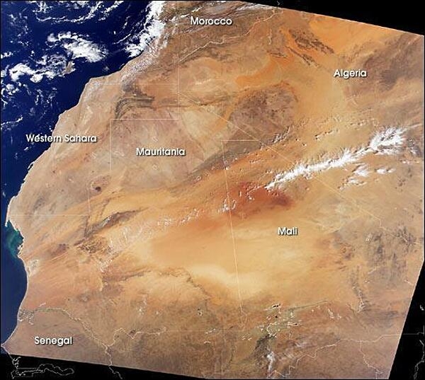 A remarkably clear satellite image of northwestern Africa vividly displays the extent of the Sahara. To the north are the dark brown Atlas Mountains of Morocco, to the west is the Atlantic Ocean, and to the south is the semi-arid (light brown) Sahelian region. The largely desert composition of Mauritania restricts human settlement. Population centers are mostly confined to the Atlantic coast or along the Senegal River in the southwest. Photo courtesy of NASA.