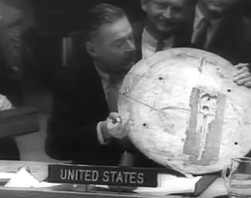Ambassador Lodge holding a wooden carving of the Great Seal of the United States